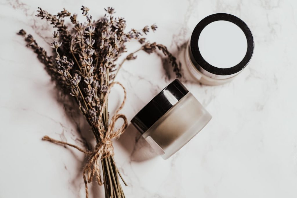 glass-cosmetic-jars-on-white-marble-surface-6167444